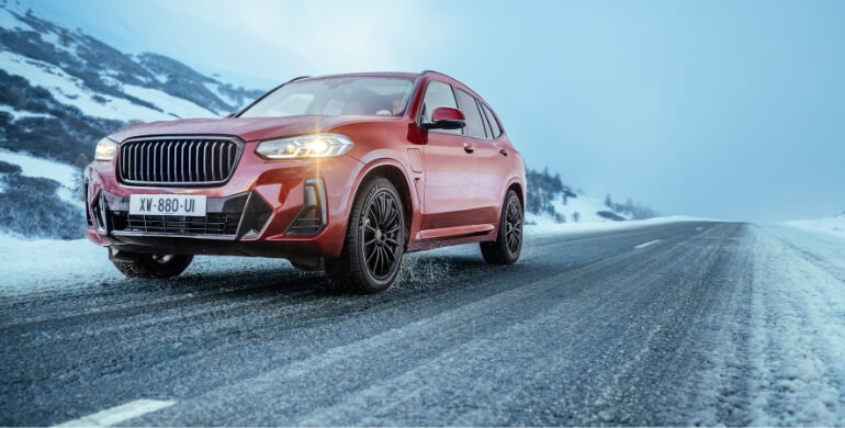 Red suv driving in the snow