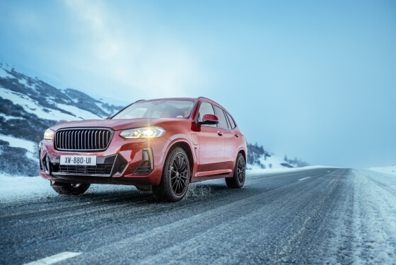 Red SUV driving on a snowy road