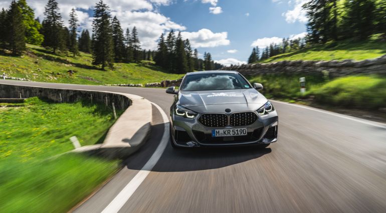The BMW M235i driving down a hill in Switzerland