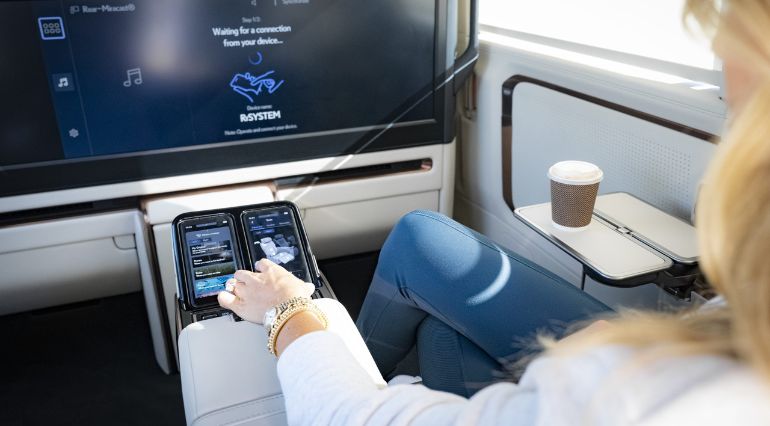 Interior of the Lecus LM with a lady seated using the touch screen infotainment centre