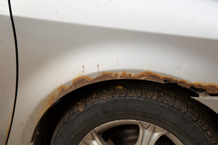 A car that appears to have rust on its side