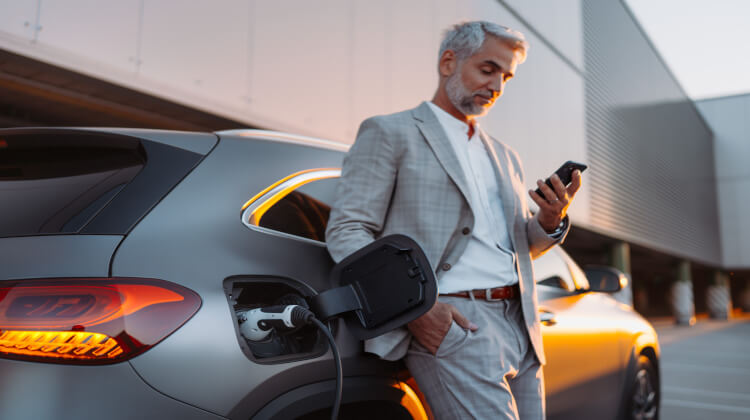 Smartly dressed electric vehicle driver parked while charging car