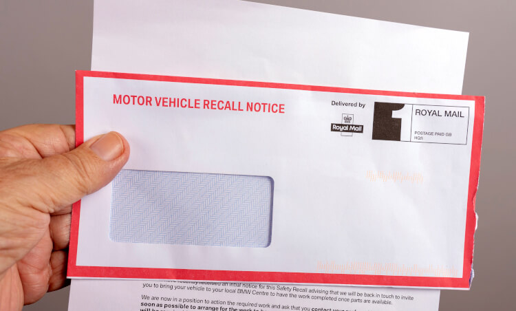 A letter with a car recall notice on the front