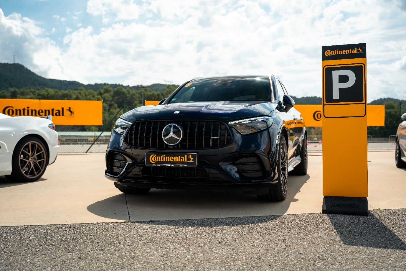 Dark blue Mercedes-AMG SUV parked beside a Continental sign at the Born to Outperform event