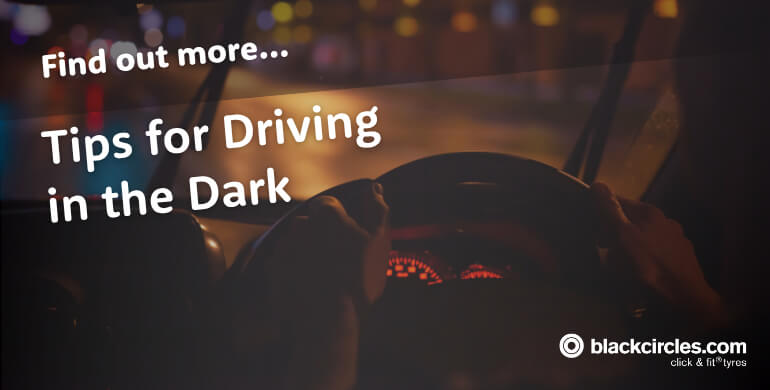 Driver holding the steering wheel while driving in the dark at night