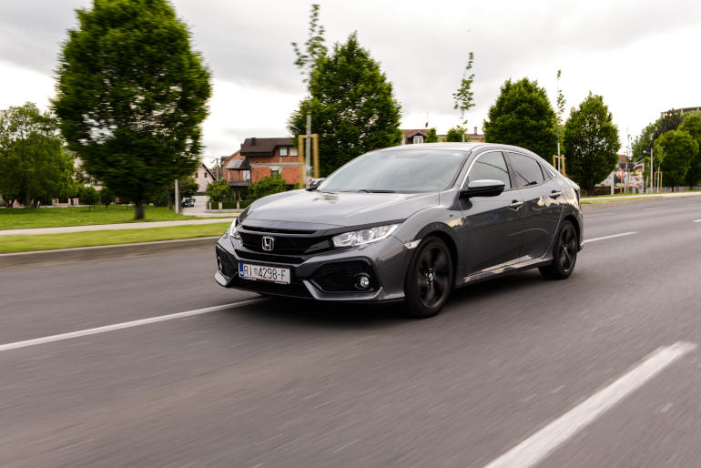 Grey Honda Civic driving on a road