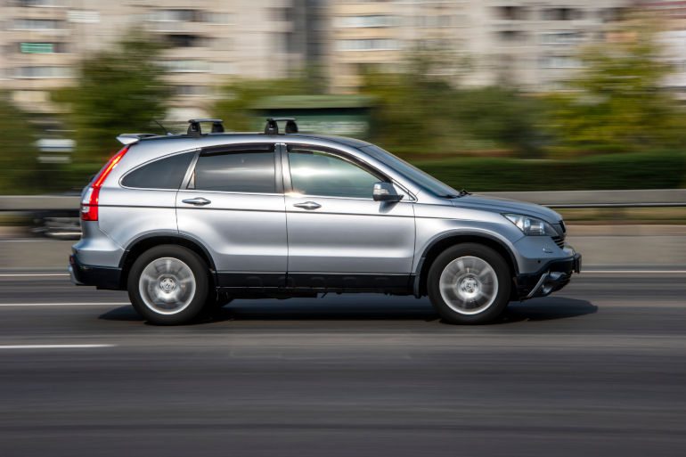 Silver Honda CRV driving on a road