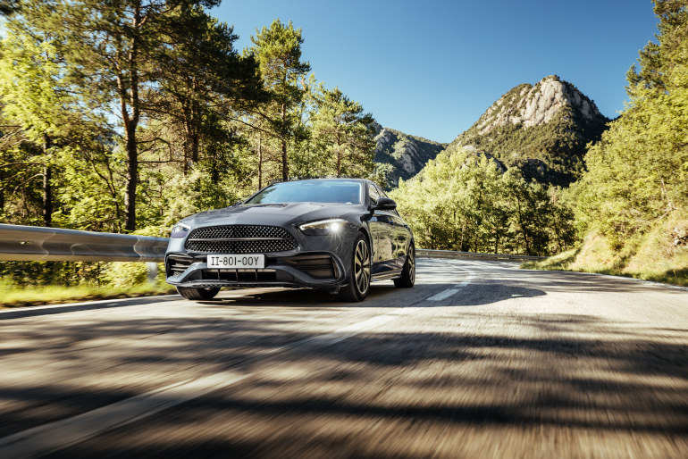 Grey car driving on a mountain road